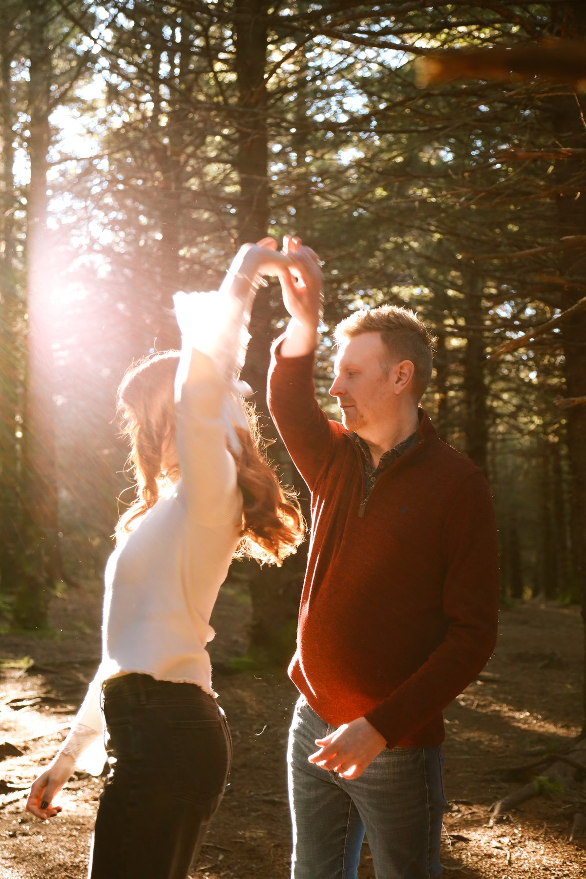 Couple laughing together in a sunlit forest